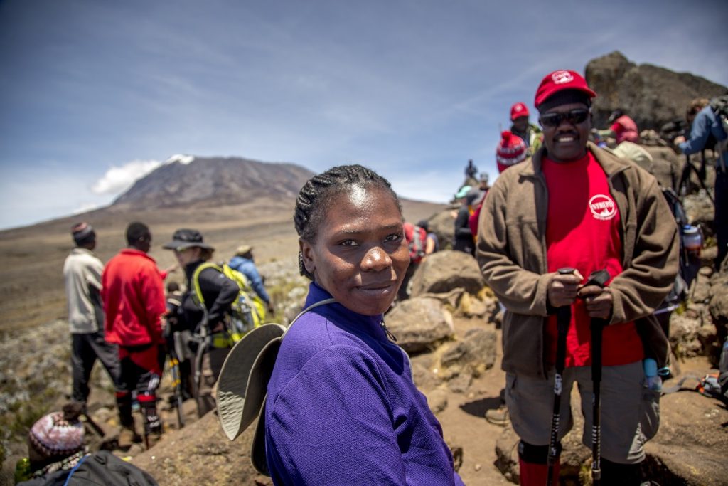 Eva Mageni Daudi, Tanzanian woman farmer and President of the Rural Women’s Farmers forum, stands stands atop Zebra Rock, 4,000 meters up Mount Kilimanjaro.