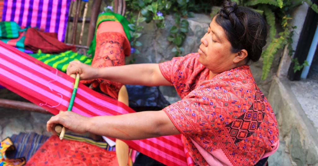 A Mayan woman in Xela, Guatemala, weaves a scarf.