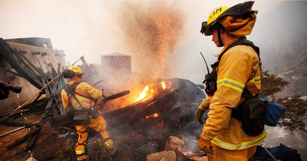 Two firefighters try to contain the Thomas fire, one of the major wildfires that burned in Southern California in December 2017.