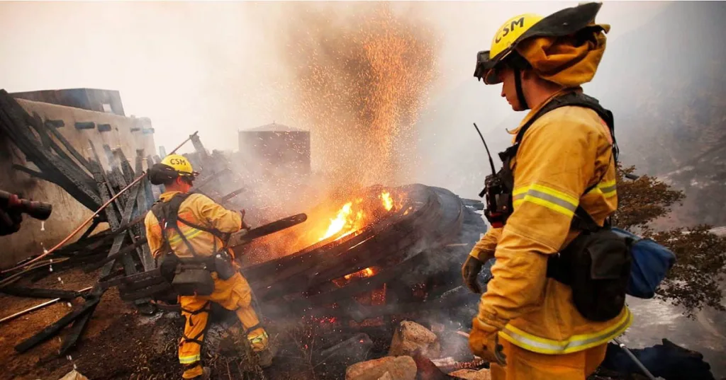 Two firefighters try to contain the Thomas fire, one of the major wildfires that burned in Southern California in December 2017.