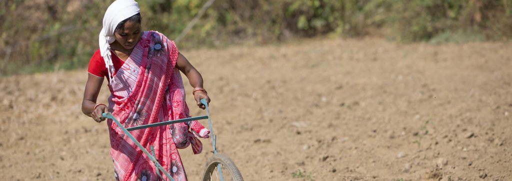 An Indian woman farmer is in a field reducing drudgery with a cycle weeder. The so-called Climate Smart Agriculture model has been criticized for not really helping small-holder farmers like her.