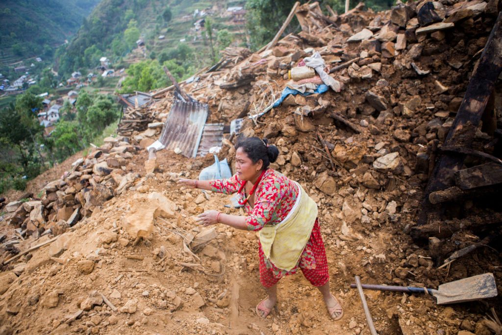 A woman clears debris from where her house stood before the 2015 Nepal earthquakes.