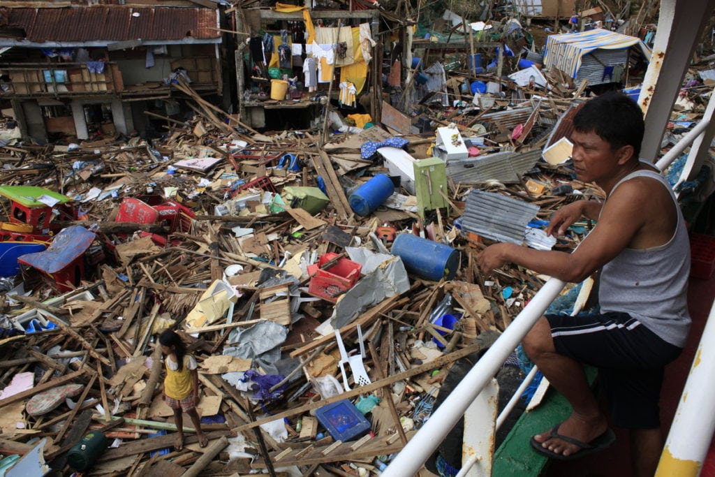 A Filipino man looks out onto a mass of wreckage caused by Typhoon Haiyan.