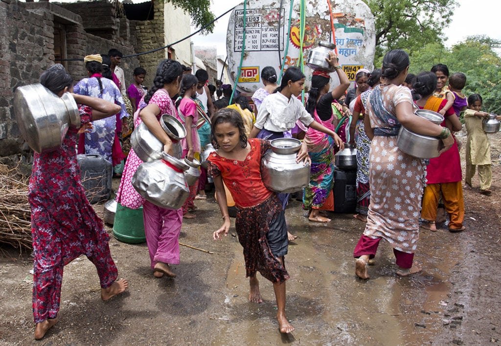 Women and girls in Parner village in Jalna district, Maharashtra, India, collect water from a tanker.