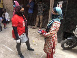 Two women with scarves wrapped around their nose and mouth face each other.