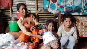 Anjana and her children receive a coronavirus prevention kit from ActionAid in Nepal.