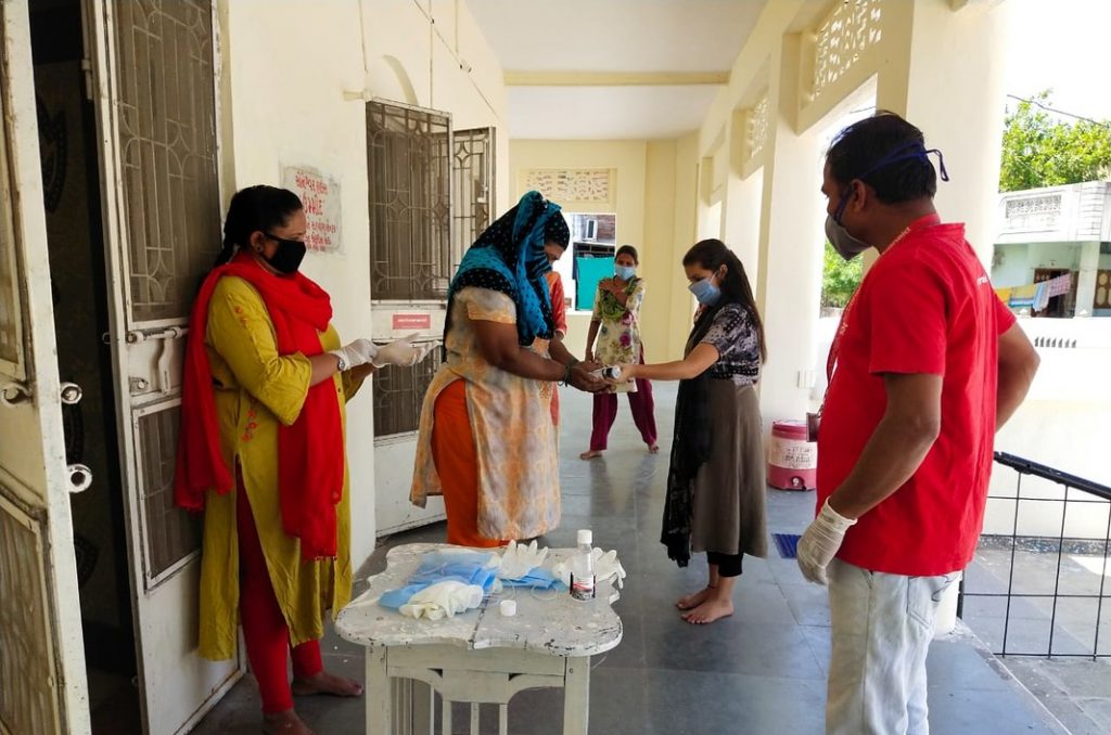 Local staff distributing dry ration kits to daily wage laborers in Gujarat. 