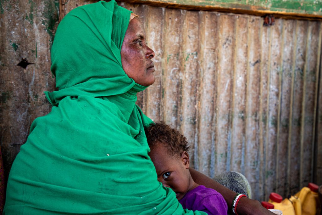 Woman holding a child and staring to the right