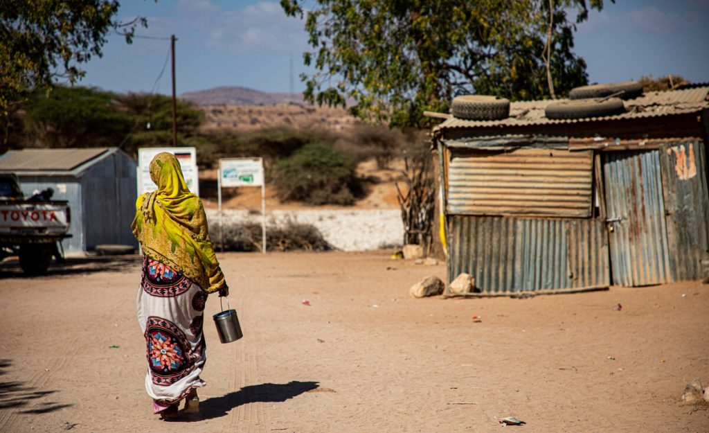 Woman walking into a makeshift camp