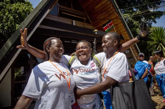 Suzy, farmer and women’s rights activist from Kenya, greets fellow Kenyan women upon her descent from the mountain. Photo: Georgina Goodwin/ActionAid